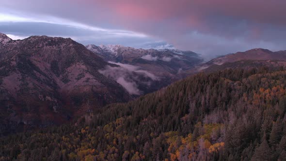 Aerial panning view of a colorful mountainside in the fall at sunset.