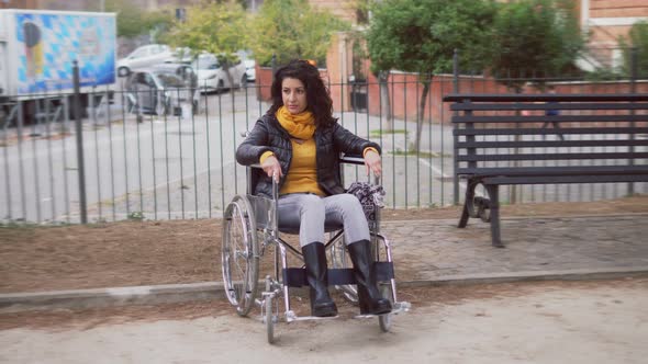 disability, solitude - young woman using wheelchair alone in the park