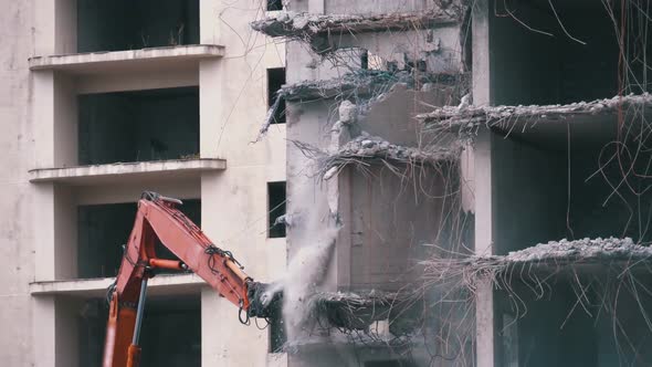 Destroying Old Concrete House Using Mechanical Arm of Bulldozer on Construction Site