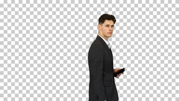 Handsome suspicious businessman walking by with a phone in a