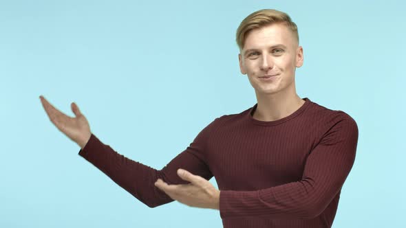 Handsome and Masculine Blond Guy Demonstrate Advertisement on Empty Copy Space Smiling Pleased at
