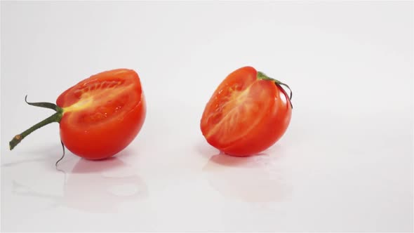 Two Halves of Tomato Breaks Hitting White Surface