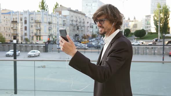 A businessman is talking via video chat with employees on the street.