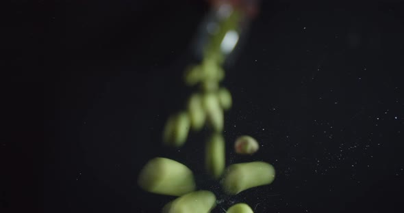 Peanuts Covered in Wasabi Are Falling on the Glass Table, 