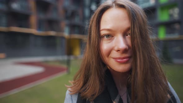 Portrait of a Gorgeous Dark Haired Woman Smiling Charmingly While Standing Against the Background of