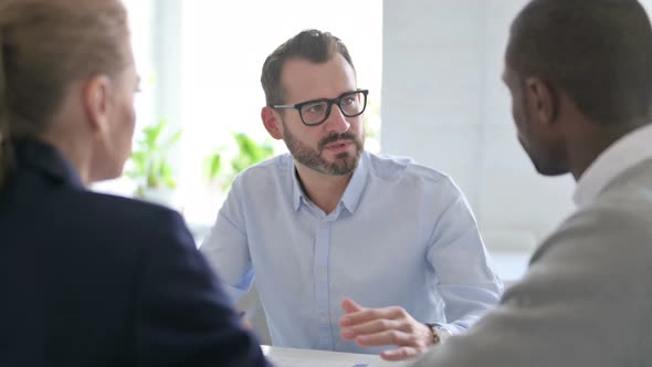 Businessman Talking to Mixed Race Business People in Office