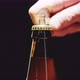 A Man Opens a Bottle of Beer on a Black Background - VideoHive Item for Sale