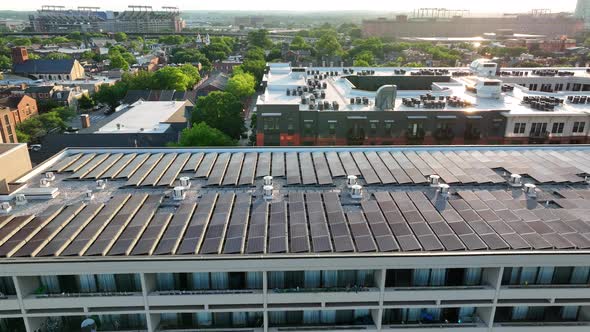 Rooftop solar panels in urban American city. Green energy theme during dramatic golden hour sunlight