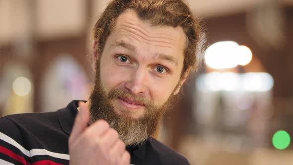 Portrait of Caucasian Bearded Man Young Adult Guy with Long Hair Gathered in Ponytail Stands Alone