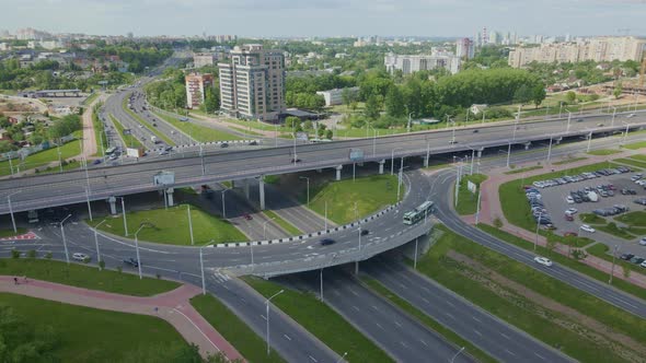 Multilevel Road Junction. Flight Along City Roads. Public Transport Is Visible.