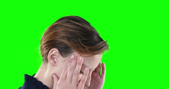 Worried Caucasian woman on green background