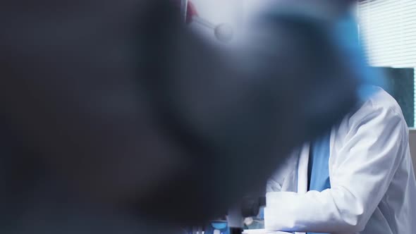 In Modern and High End Laboratory, Doctor in His 60s Is Looking at Different Tubes with Blue Samples alt