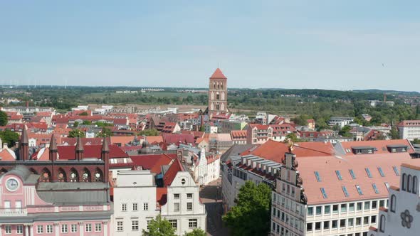 Forwards Fly Above City Hall Towards Old Tower of Nikolaikirche Church