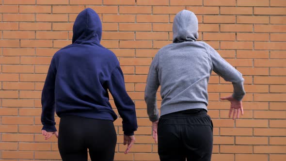 funky, hip hop - hooded girls dance performing quick and jerky movements