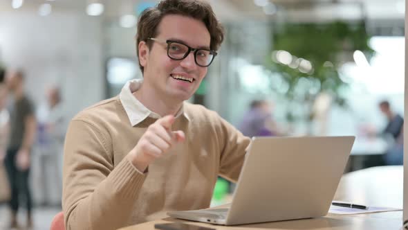 Young Male Designer With Laptop Pointing at the Camera