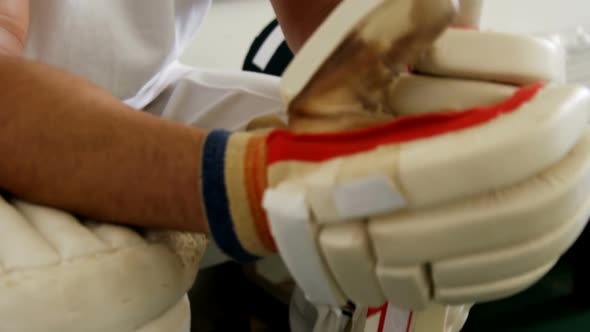 Cricket player sitting on bench in dressing room