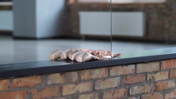 Hand of Female Dancer Taking Pair of Pointe Shoes