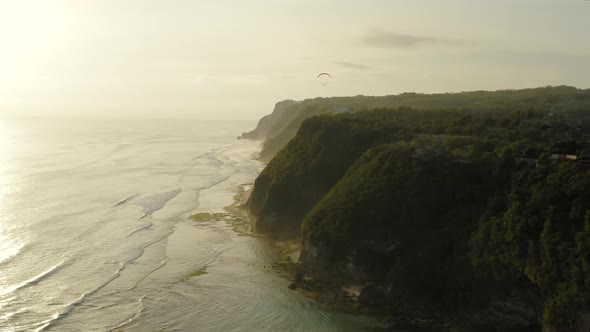 Aerial Drone Flight Over South Coast and Paraglider on the Sunset Bali Indonesia