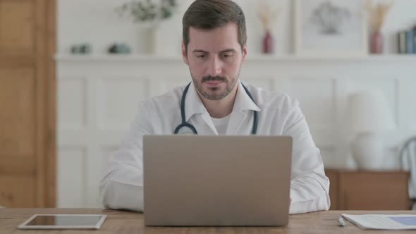 Young Doctor Working on Laptop in Clinic