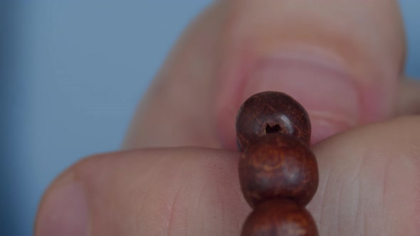 Fingers Men Close Up, Touches the Wooden Rosary