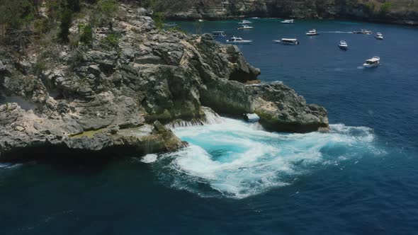 large ocean waves creating a natural whirlpool in crystal bay nusa penida bali during a sunny day, a