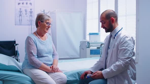 Doctor Measuring Temperature To Senior Woman