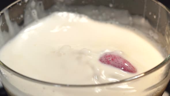 Strawberry Falling Into a Bowl with Milk Closeup