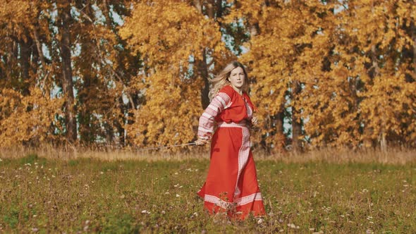 Medieval Concept - Woman in Red National Long Dress Throwing Up a Sword and Catching It