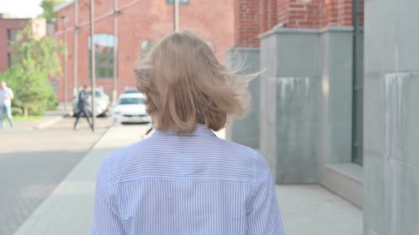 Back View of Woman Walking in Street