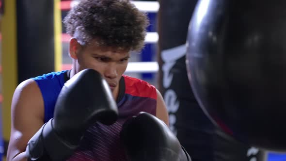 Latino Boxer Practicing with Punching Ball