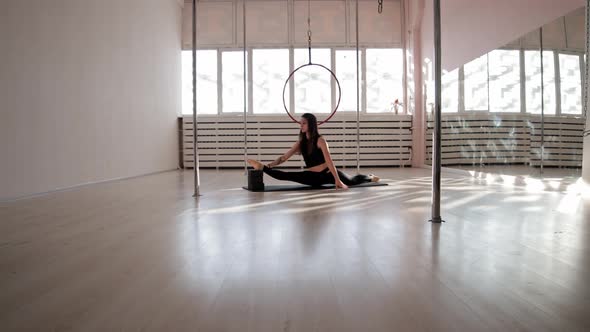 A Young Woman Sitting in a Splits and Stretching Her Legs