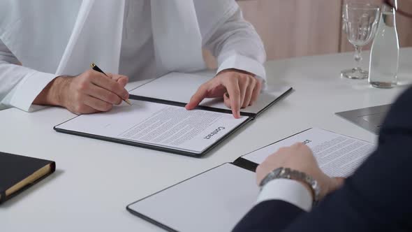 Arab Man Sign Financial Documents with a Partner Businessman While Sitting in the Office Handshake