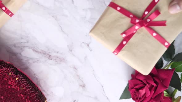 Top View of Man's Hand Holding a Gift Box on Table