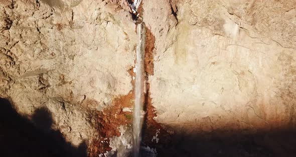 fly toward a high waterfall in sunset in Alamut death valley in Iran. sunset time in winter with fro