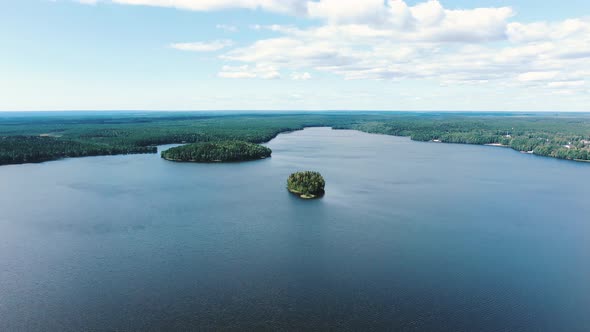 Wide Lake with Couple of Small Islands and Forest on Banks