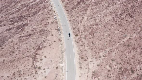 Bird’s eye view of a car driving through the Death Valley. Aerial drone shot
