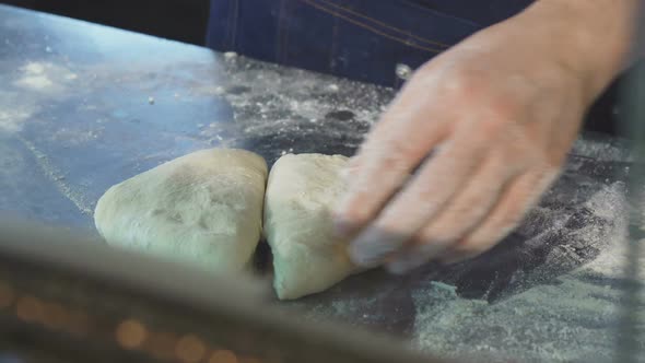 Professional Baker Cutting Dough at the Kitchen