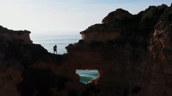 Silhouette Against the Sun a Young Guy on a Mountain Cliff is About to Make an Extreme Jump Into the