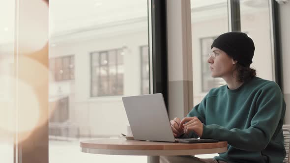 Young Male Freelancer Working in Cafe