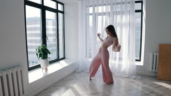 Street Dancing  Young Slim Woman Dances in White Studio