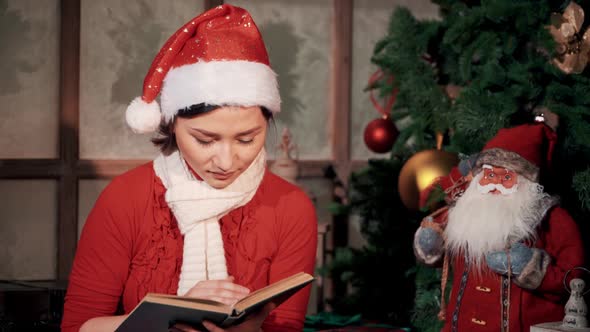 Young Girl in Front of Christmas Tree Reading Book