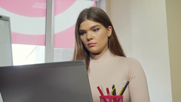 Attractive Female Student Stressing Out Looking Tired While Working on a Laptop