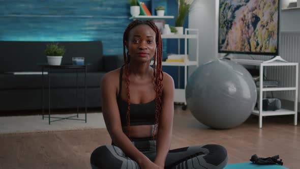 Portrait of Athlete Fit Woman Looking Into Camera While Sitting in Lotus Position