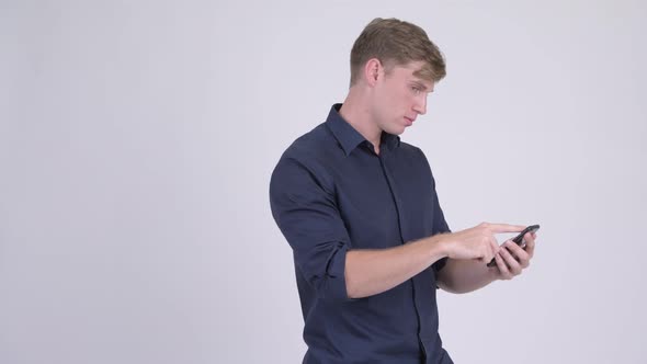 Stressed Young Businessman Using Phone and Getting Bad News