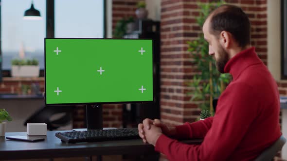 Male Employee Working with Green Screen on Monitor