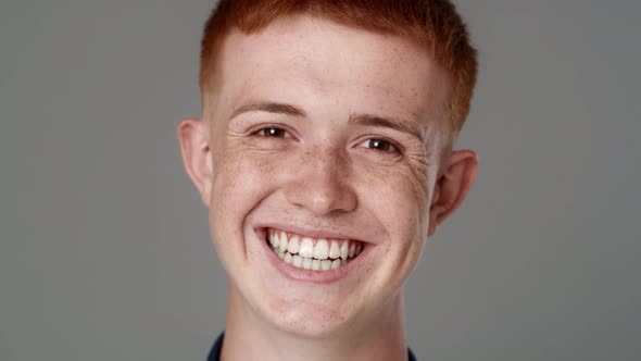 Close up portrait of red head caucasian teenage man with toothy smile. Shot with RED helium camera i