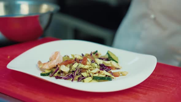 Cook Decorates the Salad with Shrimps