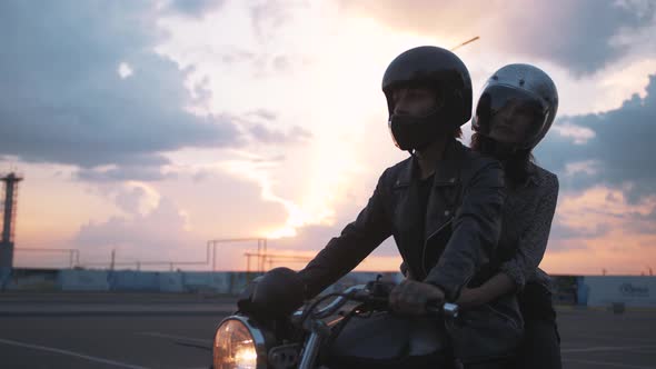 Young Couple in Helmets Riding on Motorcycle in City During Sunset Slow Motion