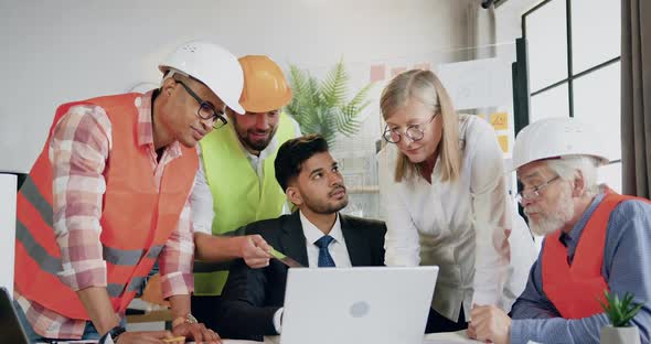 Architects Browsing Building Project on Laptop Together with Confident Skilled Bearded Head Manager