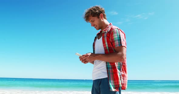 Man talking on mobile phone at beach